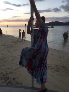 Bonnie Gillespie starts a pole trick in Fiji while others get selfies with the sunset, Feb. 2020