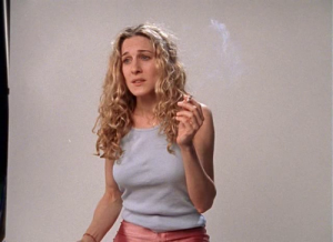 Carrie Bradshaw looking a mess after partying all night; she smokes as the photographer tests the light on her before she gets into hair and makeup